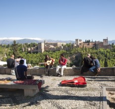 Flamenco musicians play with a backdrop of the snow Sierra Nevada mountains and the Alhambra,