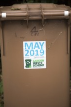 May 2019 date sticker on garden waste scheme brown compost collection bin, East Suffolk, England,