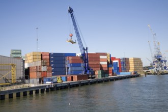 Crane and colourful containers stacked on quayside, Port of Rotterdam, Netherlands