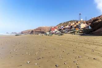 Sandy beach and buildings, Legzira, southern Morocco, north Africa