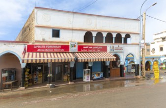 Historic buildings shops in arcaded shopping street in town centre, Mirleft, southern Morocco,