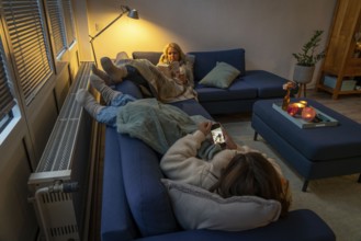 Symbolic image energy saving, cold winter, energy crisis, cold flat, mother and daughter lying on