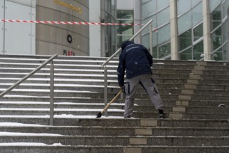 Onset of winter, winter service, clearing snow on the stairs of the Commerzbank building,