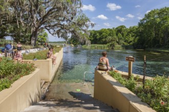 Women and teen girls sit on wall at Salt Springs Recreation Area in the Ocala National Forest,