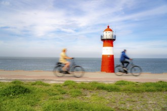 North Sea dyke near Westkapelle, Westkapelle Laag lighthouse, cyclists on the Zeeuwse Wind Route