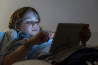 A boy plays computer games on a tablet PC