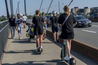 Pedestrians and e-scooters on a pavement, getting close and in each other's way, illegal driving on