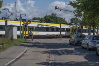 Regional train crossing a level crossing with barriers, Riegel am Kaiserstuhl, Baden-Württemberg,