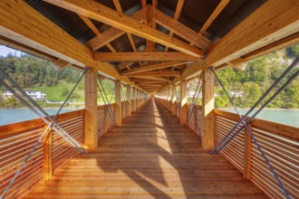 Interior view of a wooden bridge with impressive play of light and shadow and view of the river,