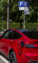 Red electric car at a charging station, Berlin, Germany, Europe