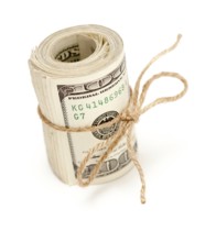 Roll of one hundred dollar bills tied with a jute string isolated on white background