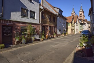 Residential houses with floral decorations, bench and the twin towers of Amorbach Abbey Church in