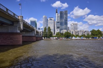 Skyscrapers and Untermainbrücke with Main river under blue sky with cumulus clouds in Frankfurt am