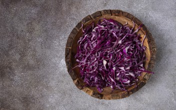 Red cabbage, sliced, in a wooden salad bowl, top view, no people