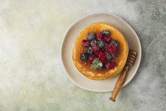 Breakfast, pancakes with berries and honey, top view, homemade, no people