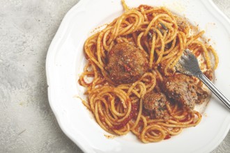 Spaghetti with meatballs in tomato sauce, on a white plate, no people, homemade