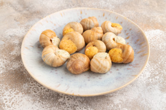 Grape (Burgundy) snails with butter and cheese on brown concrete background. Top view