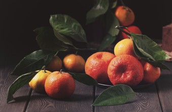 Fresh tangerines with leaves, close-up, rustic, on a wooden table, horizontal, no people