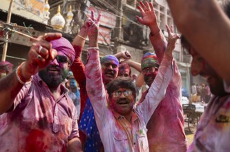 Revellers dancing in the beat of music as they celebrate Holi on a street, the Hindu spring