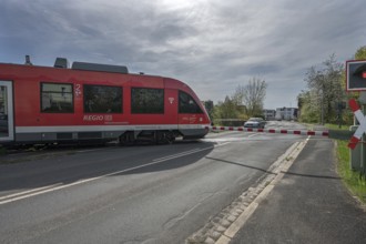 A regional train crosses a level crossing with a barrier, Schnaittach, Middle Franconia, Bavaria,