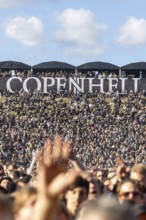 Copenhagen, Denmark - 19 June 2024: Festivalgoers in front of the logo at the Copenhell Metal