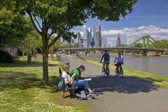 People seeking relaxation in fine weather on the Main promenade in front of the Flößerbrücke,