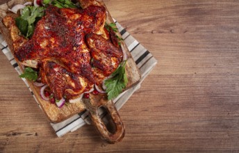 Whole fried chicken, with spices, grilled chicken, on a chopping board, top view, homemade, no