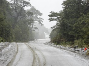 Road Carretera Austral south of village Puyuhuapi, mountain pass, gravel road, snowfall, Patagonia,