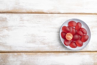 Jelly tomato candies on white wooden background. copy space, top view, flat lay