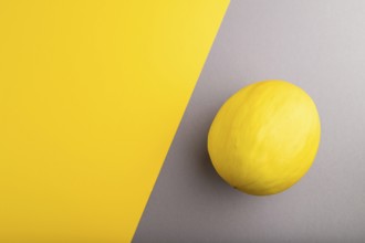 Ripe yellow melon on gray and yellow pastel background. Top view, flat lay, copy space. harvest,