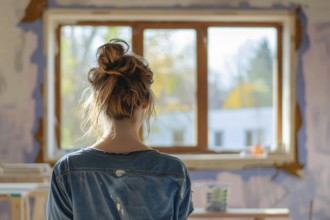 Back view of young woman in apartment room with walls in need of renovation. Generative AI, AI