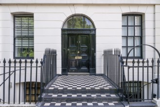 Elegant house entrance with solid black front door and white façade, Holborn, London Borough of