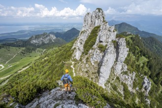 Climber on a climbing tour, on a mountain ridge, behind the summit of the Kampenwand with summit