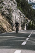 Road bike rider in spring in the Allgäu against the picturesque backdrop of the Alps, Bavaria,