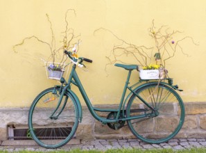 Bicycle decorated with flowers and Easter bunnies on a house wall, Sebnitz, Saxony, Germany, Europe