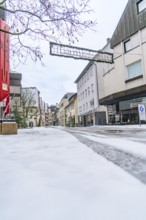 Snowy old town street with half-timbered houses under a cloudy sky, Nagold, Black Forest, Germany,