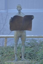 Sculpture Newspaper Reader by Karl Ulrich Nuss 2005, bronze sculpture, male figure reading a