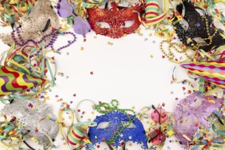 Colourful masks, paper streamers, confetti and party hats on a white background, carnival