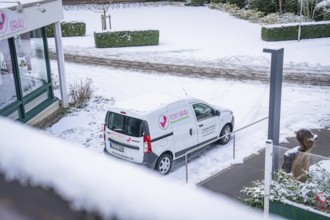 Snow-covered car park with delivery van at a shop, wintry atmosphere, spa garden, Bad Wildbad,