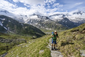 Mountaineer on hiking trail in picturesque mountain landscape, mountain peak with snow and glacier