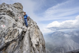 Mountaineer climbing on the rock, on a narrow rocky ridge, Watzmann crossing to the Watzmann