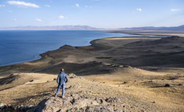 Tourist standing on a hill, view of mountain lake Song Kul, Naryn region, Kyrgyzstan, Asia