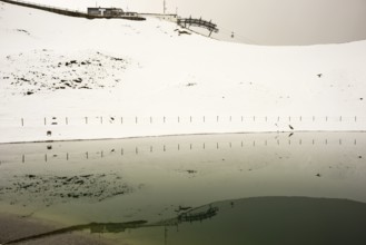 Onset of winter in May, Riezler Alpsee, an artificial lake, snow pond, feeds the snow cannons that