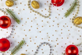 Frame made of Christmas decorations, fir branches, baubles, nuts on a white background with golden