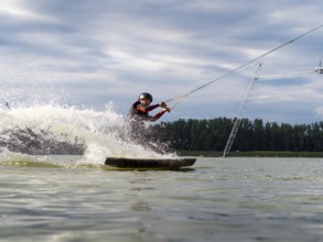 Man rides fast with wakeboard, water sports, water skiing and wakepark, Stráž pod Ralskem, Czech