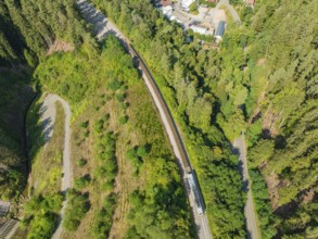 Railway line through dense forest from a bird's eye view, track construction, rail delivery for