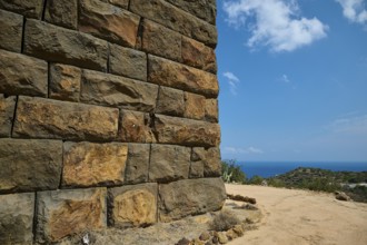 Ancient ruined wall in dry landscape overlooking the sea on a sunny day, Palaiokastro, Ancient