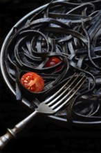 Black pasta coloured with squid ink on a plate, Taglioni al Nero di Seppia, Italy, Europe