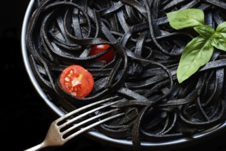 Black pasta coloured with squid ink on a plate, Taglioni al Nero di Seppia, Italy, Europe