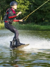 Young man doing sports with wakeboard in lake, water sports, water skiing in wakepark, Stráž pod